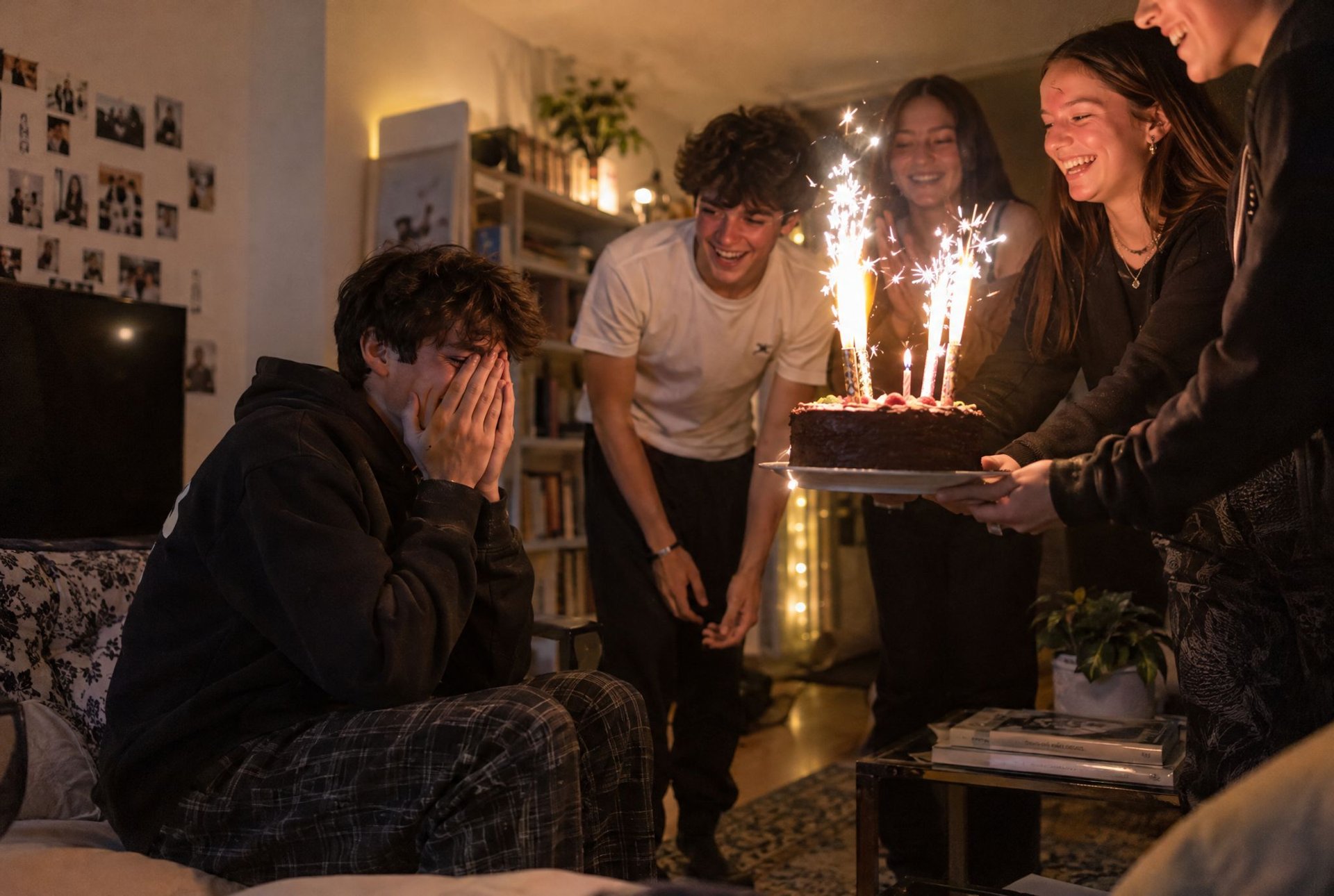 Amis réunis autour d'un gâteau aux bougies scintillantes lors d'une soirée d'anniversaire à la maison