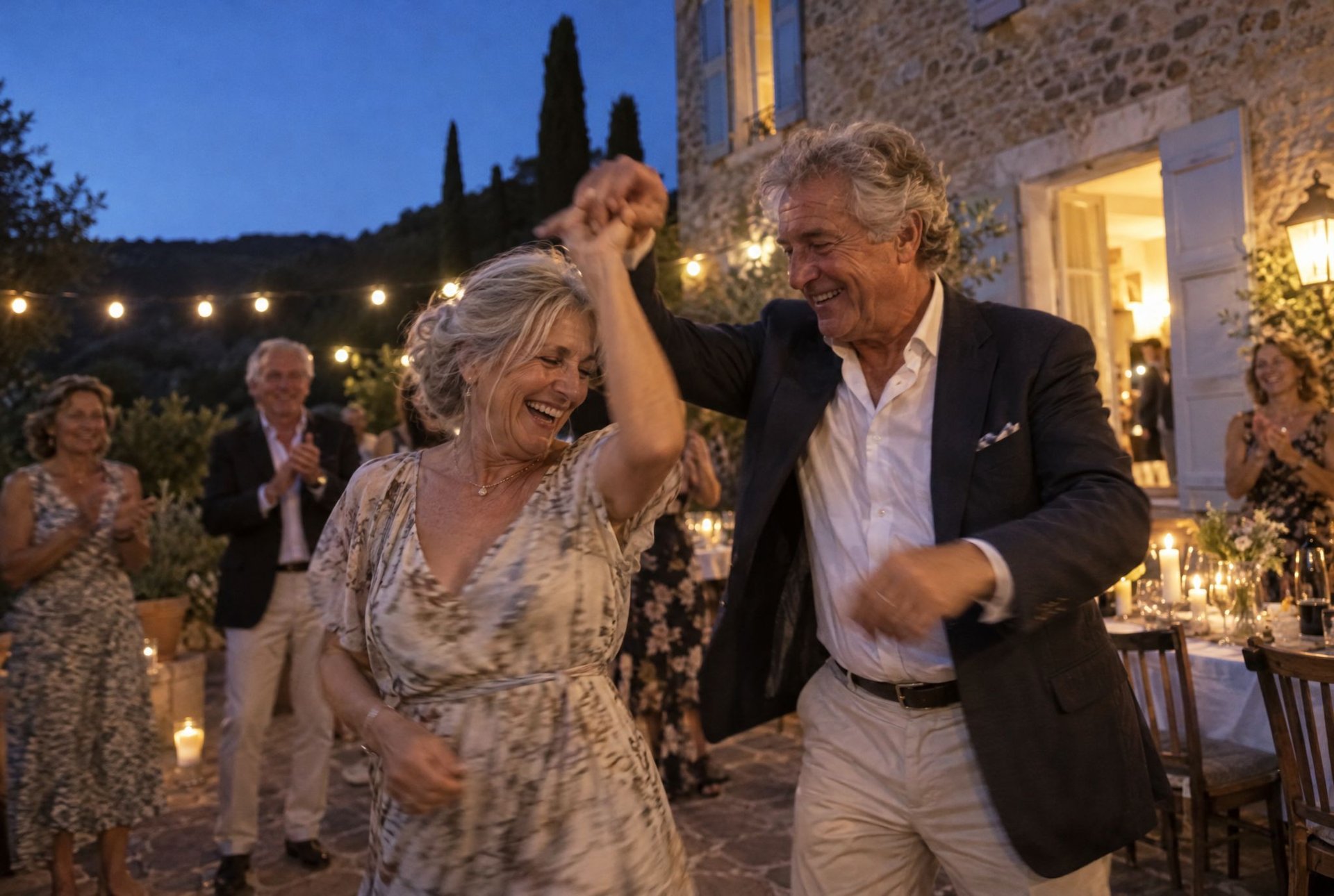 Couple dansant main dans la main lors d'une fête d'anniversaire en extérieur à la tombée de la nuit